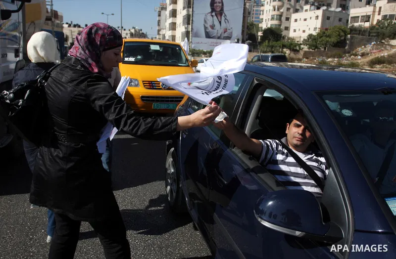 Activists of the Palestine 194 campaign distribute flags and leaflets to motorists in order to drum for Palestine to become the 194th state recognised by the UN, in the West bank town of Ramallah, on 13 September 2011. T...