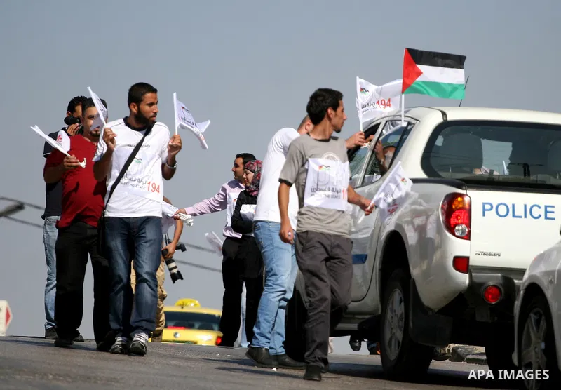 Activists of the Palestine 194 campaign distribute flags and leaflets to motorists in order to drum for Palestine to become the 194th state recognised by the UN, in the West bank town of Ramallah, on 13 September 2011. T...
