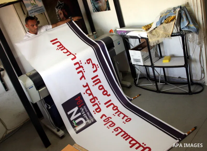 A Palestinian worker inspects a banner as it prints in the West Bank city of Ramallah September 13, 2011. A grass-root campaign supporting the upcoming Palestinian bid at the United Nations is gearing up for the diplomat...