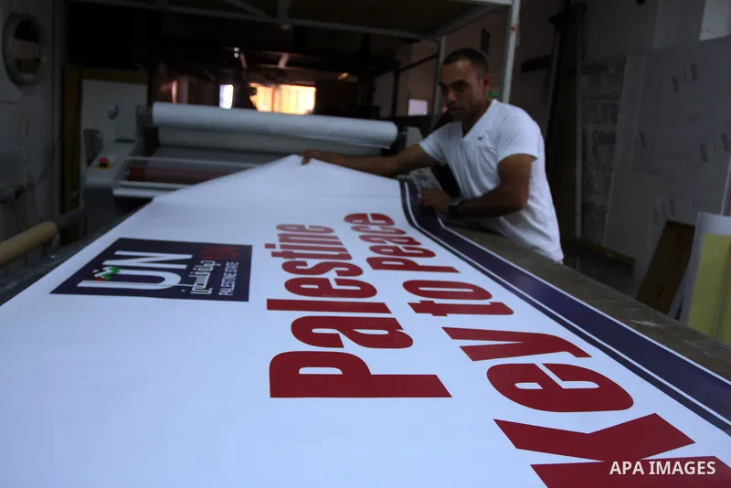 A Palestinian worker inspects a banner as it prints in the West Bank city of Ramallah September 13, 2011. A grass-root campaign supporting the upcoming Palestinian bid at the United Nations is gearing up for the diplomat...