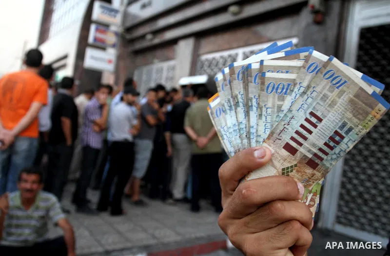 Palestinian Authority civil servants gather outside the Arab Bank in Gaza city on Sep. 13,2011, to withdraw their monthly salaries which were delayed for ten days from the begining of the new month. Photo by Mohammed Asa...