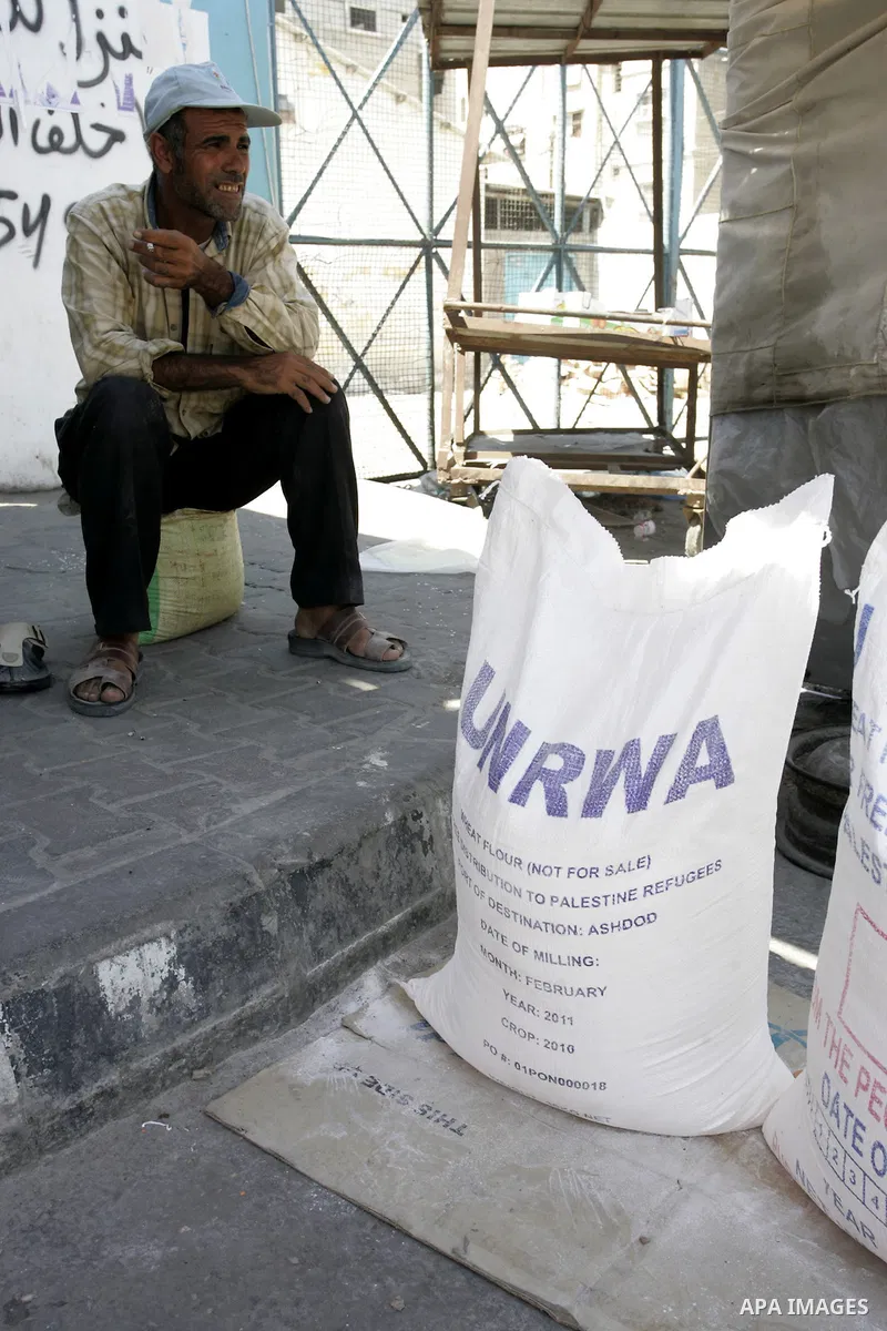 A Palestinian man sits near food aid receiving from a UN distribution centre in the Rafah refugee camp, southern Gaza Strip on Sep. 14, 2011. Germany provided for the first time a donation to the school's nutrition progr...