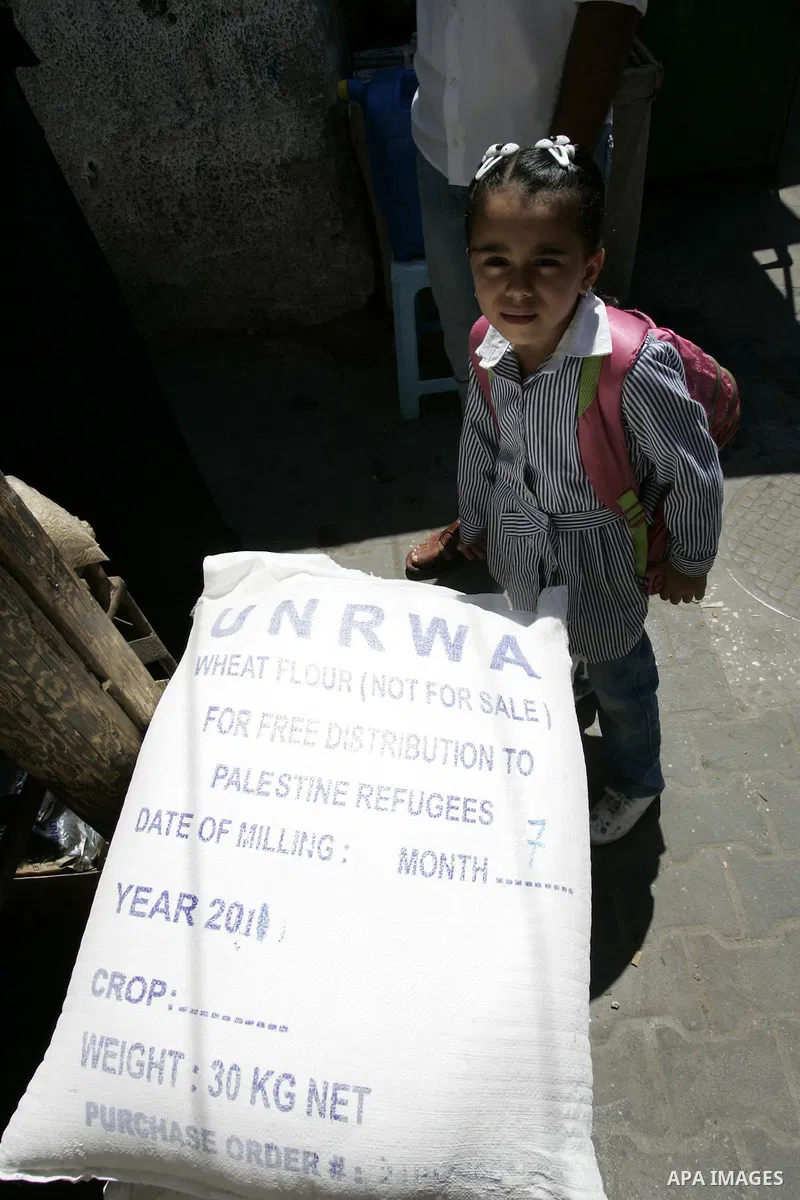 A Palestinian girl stands near food aid receiving from a UN distribution centre in the Rafah refugee camp, southern Gaza Strip on Sep. 14, 2011. Germany provided for the first time a donation to the school's nutrition pr...