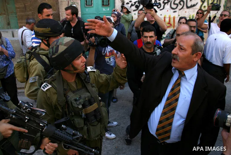 A Palestinian man argues with Israeli soldiers during a rally against the closure of Shuhada Street in Hebron, the main artery blocked by an Israeli military checkpoint in the center of the West Bank town of Hebron Sep....