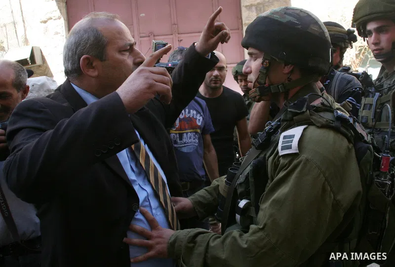 A Palestinian man argues with Israeli soldiers during a rally against the closure of Shuhada Street in Hebron, the main artery blocked by an Israeli military checkpoint in the center of the West Bank town of Hebron Sep....