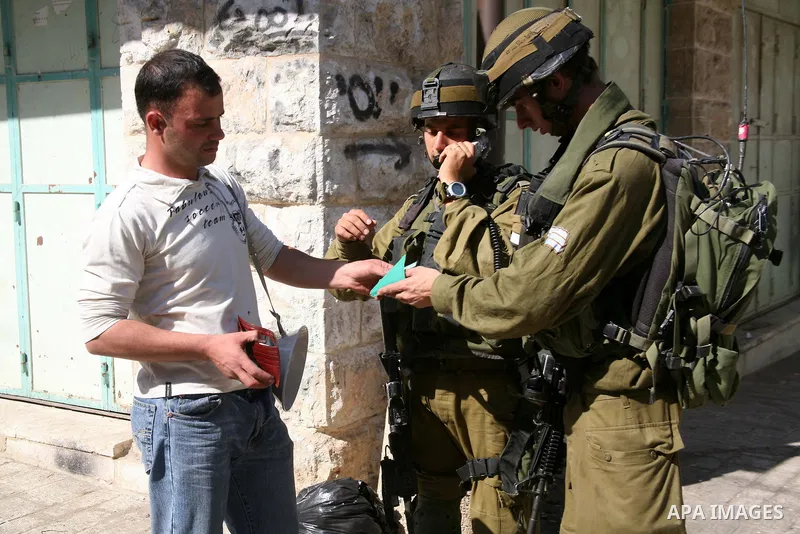 A Palestinian man argues with Israeli soldiers during a rally against the closure of Shuhada Street in Hebron, the main artery blocked by an Israeli military checkpoint in the center of the West Bank town of Hebron Sep....