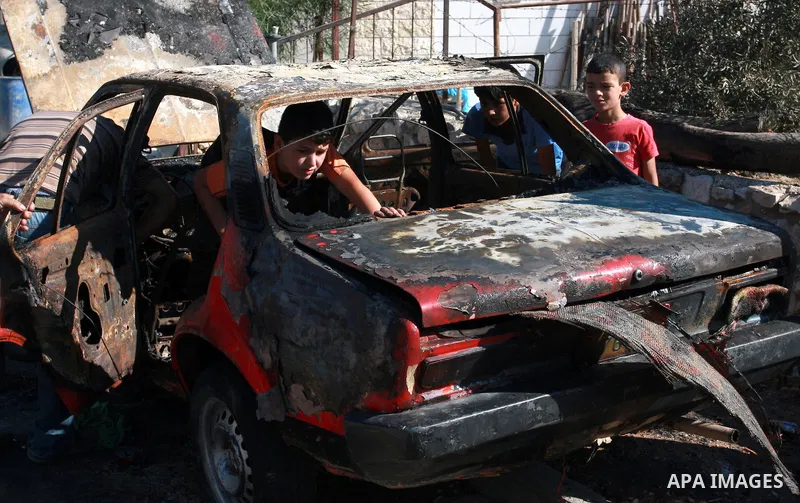 Palestinians inspect a burnt car in the village of Beit Furik, near the West Bank town of Nablus, on Sept. 15, 2011. Vandals set fire to three cars in a West Bank village, and suspicion has fallen on Jewish settlers. Pal...