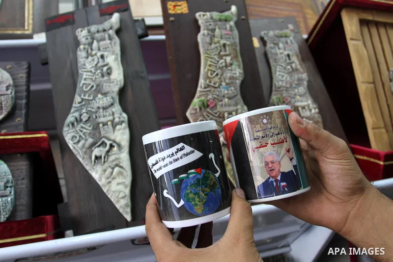 Coffee mugs stand for sale at a souvenirs shop, some of them with a printed picture of the Palestinian President Mahmoud Abbas (Abu Mazen) and others reading 'The world wants the state of Palestine', in Gaza City, on Sep...