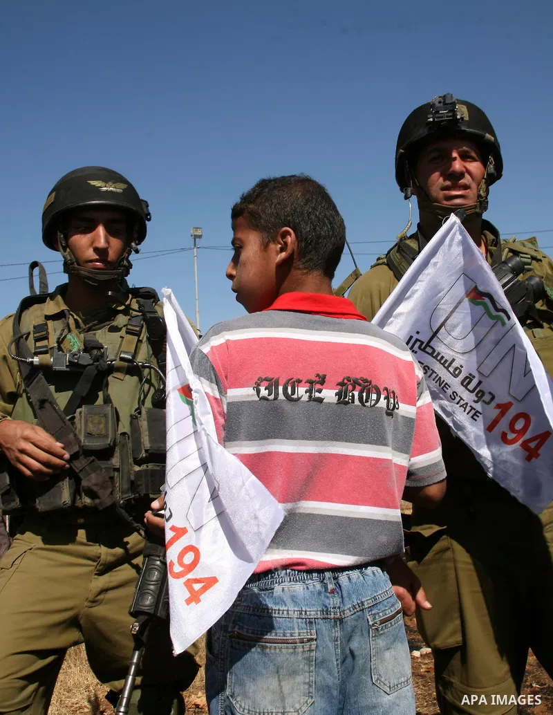Israeli soldiers stand by as Palestinian and international activists work on a Palestinian's farm land in the West Bank village of Beit Omar near Hebron, 16 September 2011. The Israeli soldiers eventually dispersed the p...