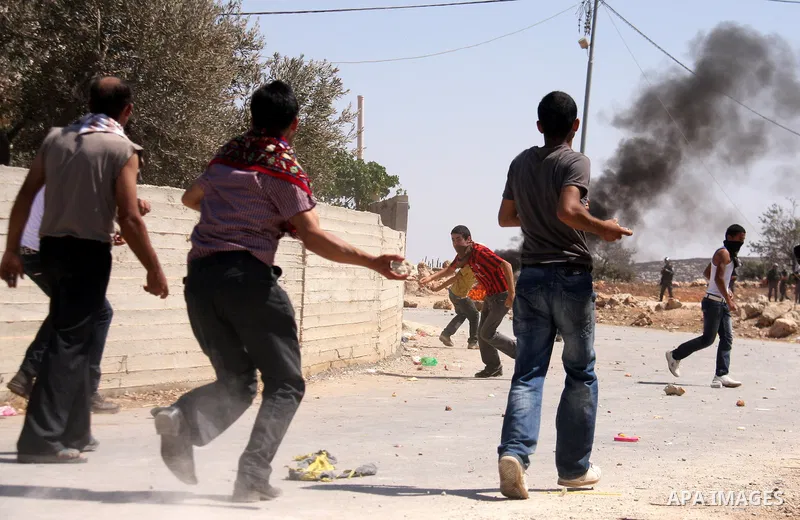 Palestinians hurl rocks at Israeli soldiers during clashes at Qusra village near the West Bank city of Nablus on 16 September 2011. Israeli settlers assaulted the village Friday morning, leading to clashes with Israeli f...