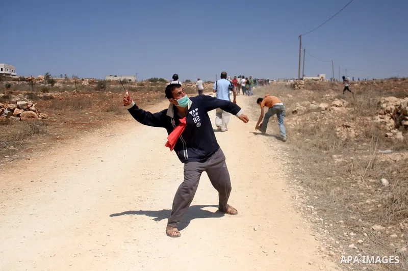 Palestinians hurl rocks at Israeli soldiers during clashes at Qusra village near the West Bank city of Nablus on 16 September 2011. Israeli settlers assaulted the village Friday morning, leading to clashes with Israeli f...