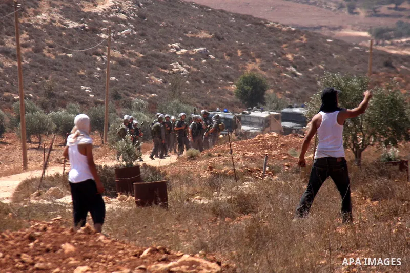 Palestinians hurl rocks at Israeli soldiers during clashes at Qusra village near the West Bank city of Nablus on 16 September 2011. Israeli settlers assaulted the village Friday morning, leading to clashes with Israeli f...