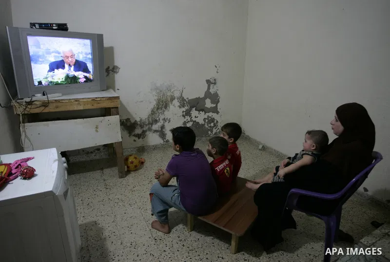 Palestinians watch a television broadcasting the speech of president Mahmud Abbas in Rafah, southern Gaza Strip, on September 16, 2011 in which Abbas vowed to lodge a bid for UN membership before the Security Council in...