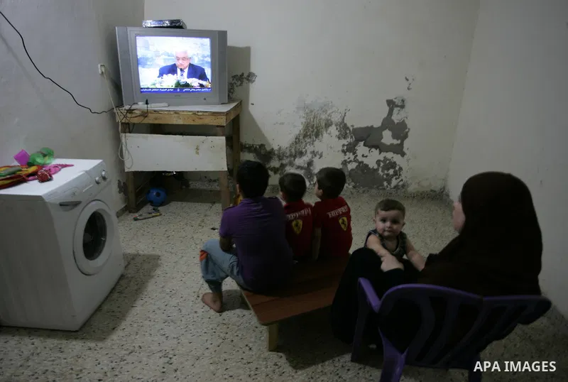 Palestinians watch a television broadcasting the speech of president Mahmud Abbas in Rafah, southern Gaza Strip, on September 16, 2011 in which Abbas vowed to lodge a bid for UN membership before the Security Council in...