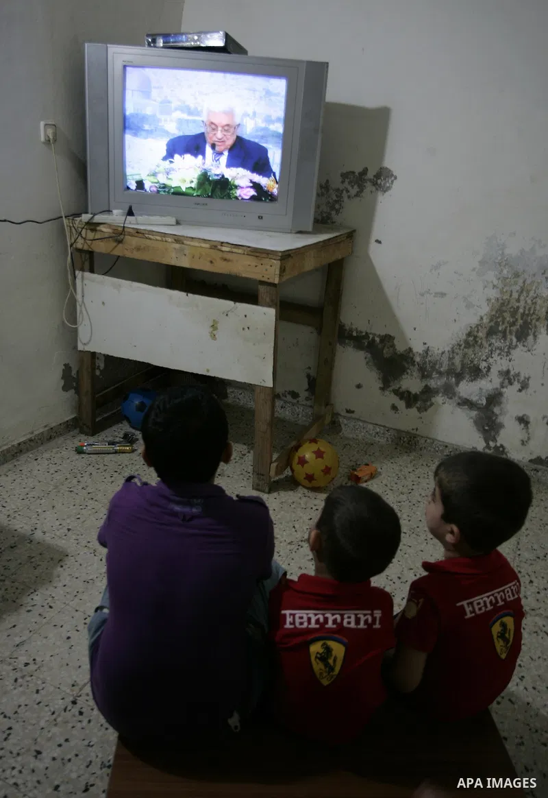Palestinians watch a television broadcasting the speech of president Mahmud Abbas in Rafah, southern Gaza Strip, on September 16, 2011 in which Abbas vowed to lodge a bid for UN membership before the Security Council in...
