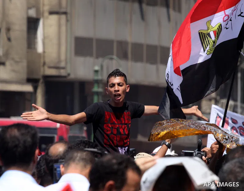 An Egyptian youth waves the Egyptian flag at Tahrir Square while hundreds of Egyptians demonstrate against the expansion of the Emergency Law at Al Tahrir Square. The law allows censorship, government imprisonment and mo...