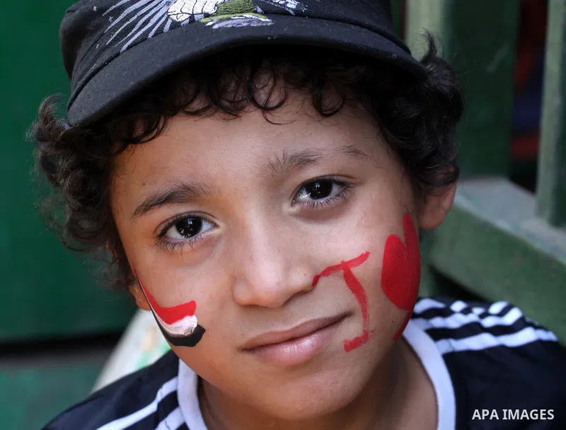 An Egyptian boy paints the Egyptian flag on his face at Tahrir Square while hundreds of Egyptians demonstrate against the expansion of the Emergency Law at Al Tahrir Square. The law allows censorship, government imprison...