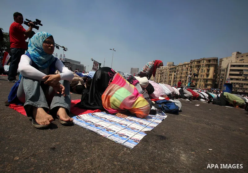 Egyptians during performing their Friday prayers while hundreds of Egyptians demonstrate against the expansion of the Emergency Law at Al Tahrir Square. The law allows censorship, government imprisonment and more during...