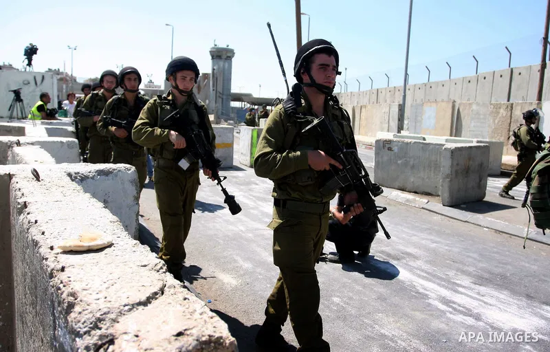 Israeli forces walk at the Qalandia Israeli checkpoint during a protest calling for a Palestinian state with full UN membership, in the West Bank, near Ramallah, on Sep. 17, 2011. The Palestinians are preparing to submit...