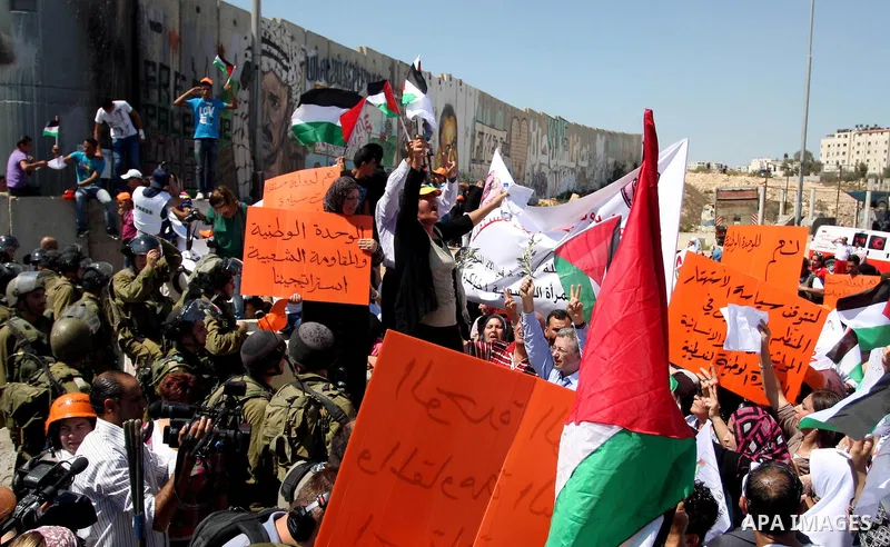 Palestinians wave national flags during a protest calling for a Palestinian state with full UN membership at the Qalandia Israeli checkpoint in the West Bank, near Ramallah, on Sep. 17, 2011. The Palestinians are prepari...