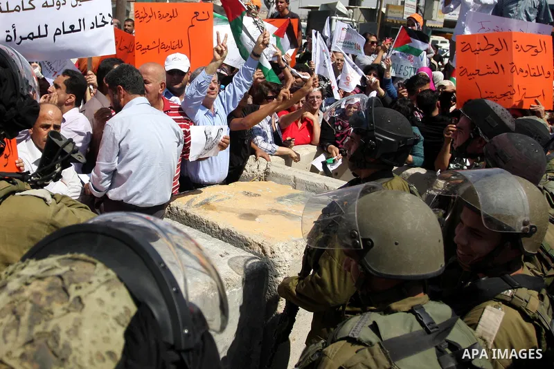 Palestinians wave national flags during a protest calling for a Palestinian state with full UN membership at the Qalandia Israeli checkpoint in the West Bank, near Ramallah, on Sep. 17, 2011. The Palestinians are prepari...