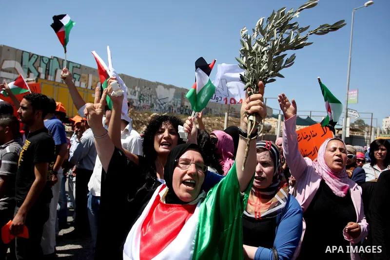 Palestinians wave national flags during a protest calling for a Palestinian state with full UN membership at the Qalandia Israeli checkpoint in the West Bank, near Ramallah, on Sep. 17, 2011. The Palestinians are prepari...