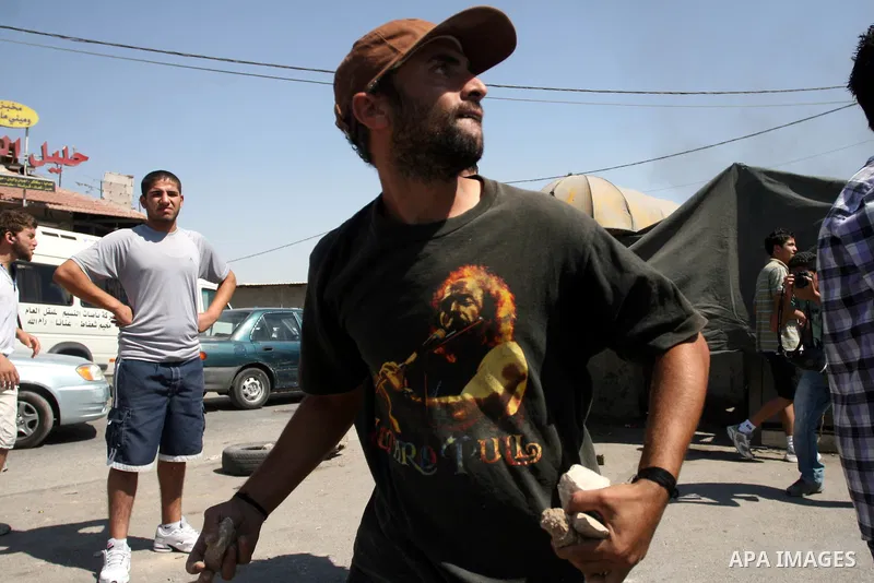 Palestinian youths throw stones at Israeli forces during a protest calling for a Palestinian state with full UN membership at the Qalandia Israeli checkpoint in the West Bank, near Ramallah, on Sep. 17, 2011. The Palesti...