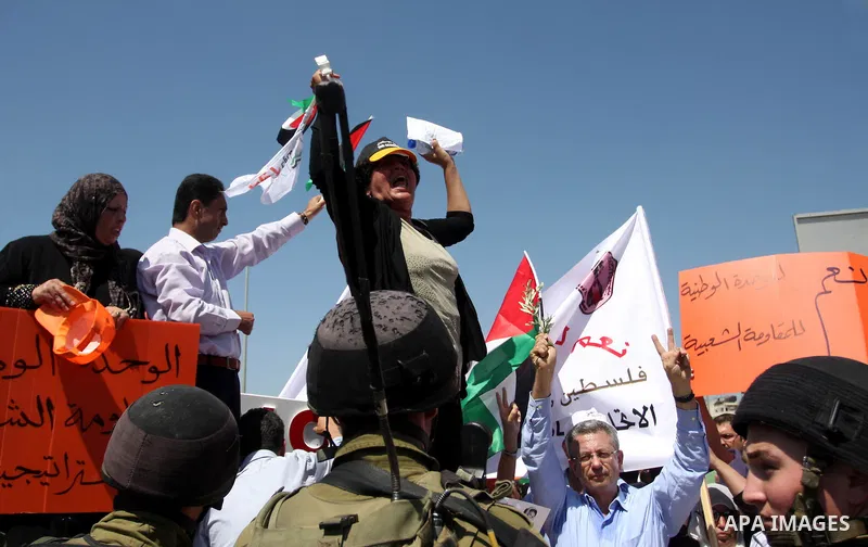 Palestinians wave national flags during a protest calling for a Palestinian state with full UN membership at the Qalandia Israeli checkpoint in the West Bank, near Ramallah, on Sep. 17, 2011. The Palestinians are prepari...
