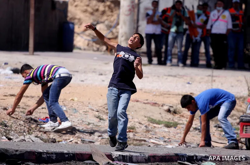 Palestinian youths throw stones at Israeli forces during a protest calling for a Palestinian state with full UN membership at the Qalandia Israeli checkpoint in the West Bank, near Ramallah, on Sep. 17, 2011. The Palesti...