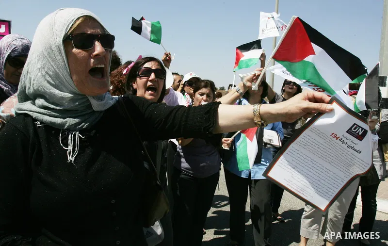 Palestinian women, joined by foreign peace activists and left-wing Israelis, hold up placards calling for a Palestinian state with full UN membership during a protest in Jerusalem, on 17 September 2011. Palestine is set...