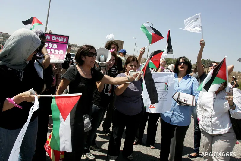 Palestinian women, joined by foreign peace activists and left-wing Israelis, hold up placards calling for a Palestinian state with full UN membership during a protest in Jerusalem, on 17 September 2011. Palestine is set...