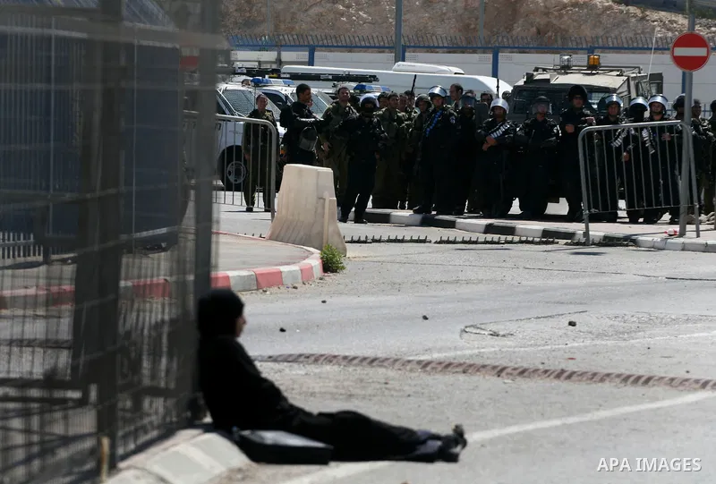 A Palestinian woman who identified herself as Neda, from the West Bank city of Bethlehem, sit in defiance within the crossing point of Qalandia at the entrance of Jerusalem on September 17, 2011, in a zone otherwise stri...