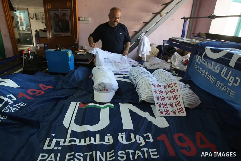 Palestinian man folds t-shirts bearing a symbolic emblem of a proposed future Palestinian state at a work shop in the West Bank city of Nablus .Saturday,Sept. 17, 2011. Palestinian President Mahmoud Abbas is set to addre...