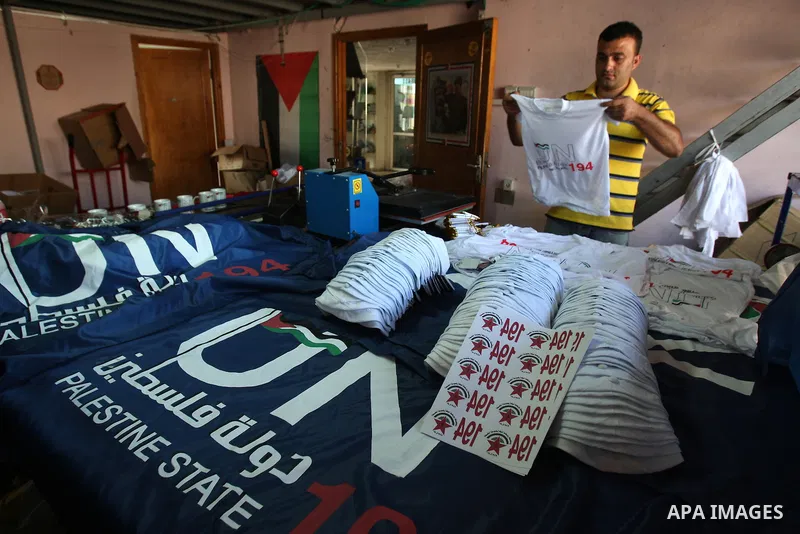 Palestinian man folds t-shirts bearing a symbolic emblem of a proposed future Palestinian state at a work shop in the West Bank city of Nablus .Saturday,Sept. 17, 2011. Palestinian President Mahmoud Abbas is set to addre...
