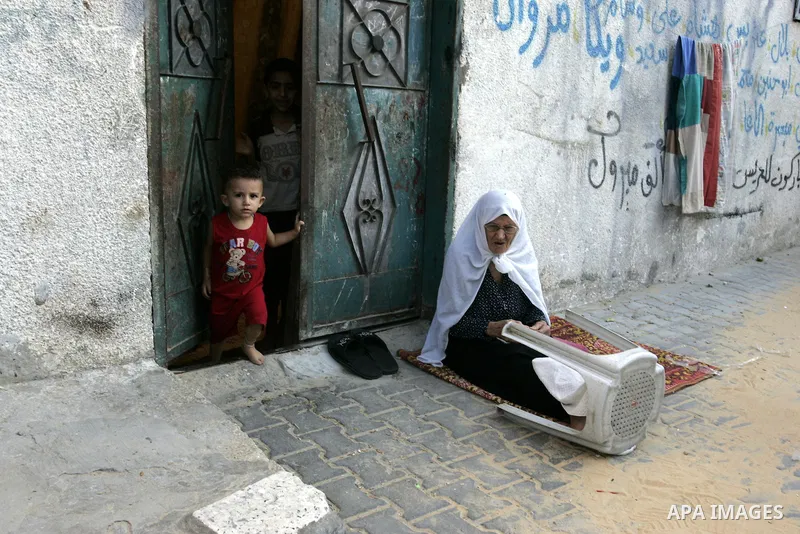 A Palestinian woman sits outside her house with her child at Rafah refugee camp, southern Gaza Strip on Sep. 17, 2011. The Palestinians are preparing to submit a formal request to become the 194th member of the United Na...