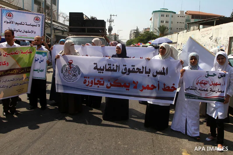 Palestinians take part in a protest in front of the UNRWA headquarters, against reducing the services provided to Palestine refugees in Gaza city, on Sep. 18, 2011. Photo by Ashraf Amra
