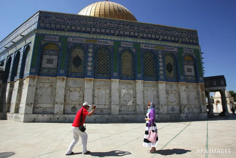 A group of religious Jews walks in front of the Dome of the Rock on a visit to the Al-Aqsa mosques compound under Israeli police protection in Jerusalem's Old City on September 18, 2011. The Dome of the Rock (C), Islam's...