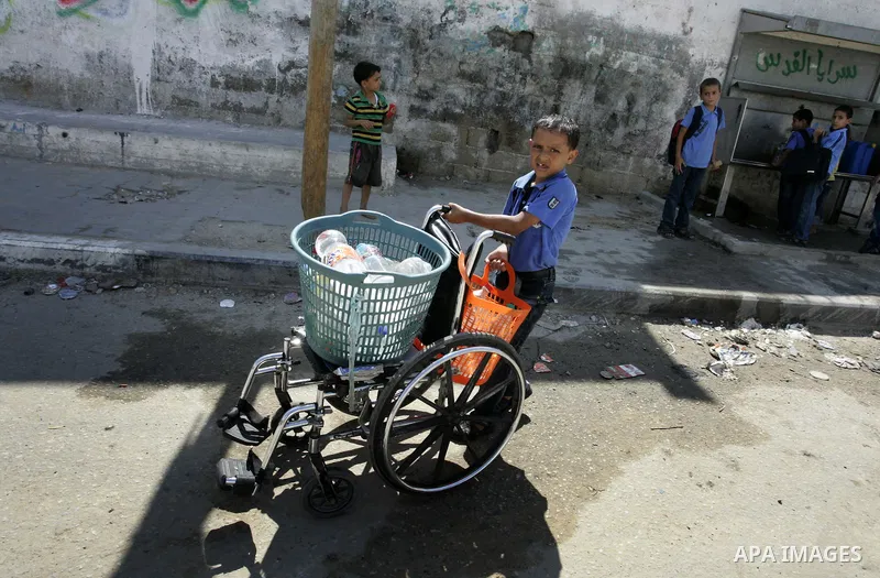 Palestinian children fill bottles from a public water tap at the United Nations Relief and Works Agency (UNRWA) headquarters, in Rafah refugee camp in the southern Gaza strip on September 18, 2011. The Palestinians are p...