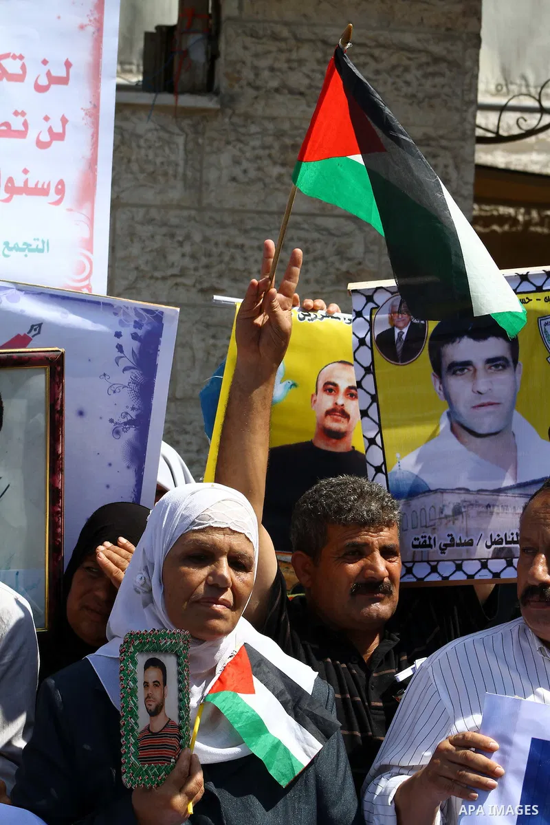 Palestinians hold pictures of their prisoned relatives in Israeli jails as they gather in a weekly activity calling for their liberty at the Red Cross headquarters in Gaza City on Sep. 19, 2011. About 7000 prisoners are...