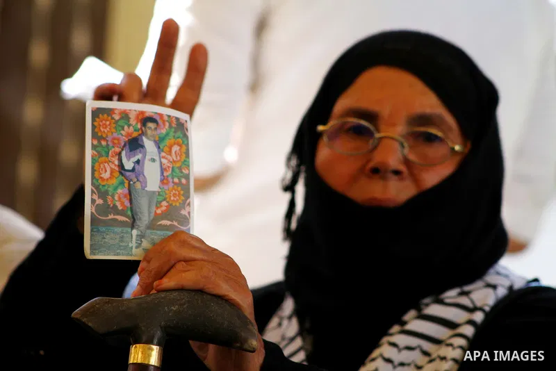 A Palestinian woman holds picture of her prisoned relatives in Israeli jails as they gather in a weekly activity calling for their liberty at the Red Cross headquarters in Gaza City on Sep. 19, 2011. About 7000 prisoners...