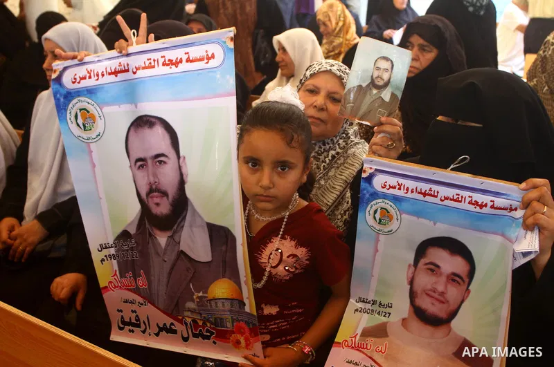 Palestinian women hold pictures of their prisoned relatives in Israeli jails as they gather in a weekly activity calling for their liberty at the Red Cross headquarters in Gaza City on Sep. 19, 2011. About 7000 prisoners...