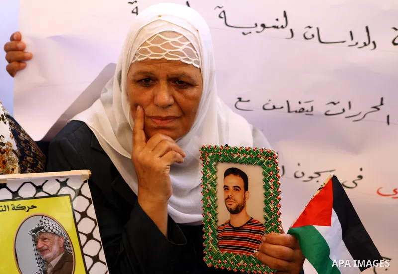A Palestinian woman holds picture of her prisoned relatives in Israeli jails as they gather in a weekly activity calling for their liberty at the Red Cross headquarters in Gaza City on Sep. 19, 2011. About 7000 prisoners...