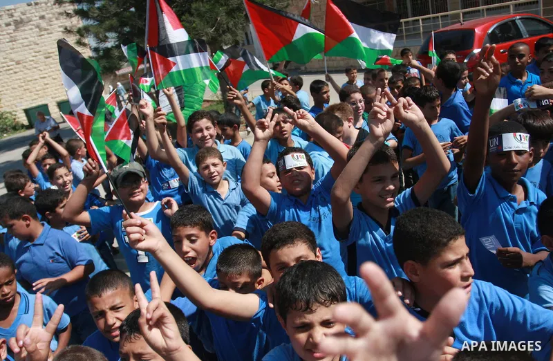 Palestinian schoolchildren hold their national flag during a rally in the West Bank city of Tulkarem, Monday, Sept. 19, 2011. Abbas is set to address the U.N. this week, planning to ask the world to recognize a Palestini...