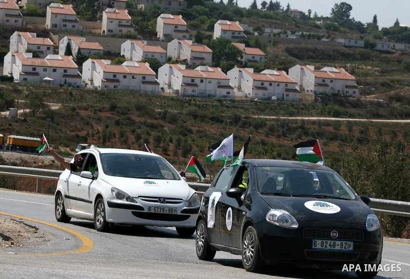 Palestinians wave their national flag during the launch of pro-Palestinian volunteer-based campaign which will intervene and respond to cases of violence towards Palestinians by Jewish settlers in the West Bank, in the W...