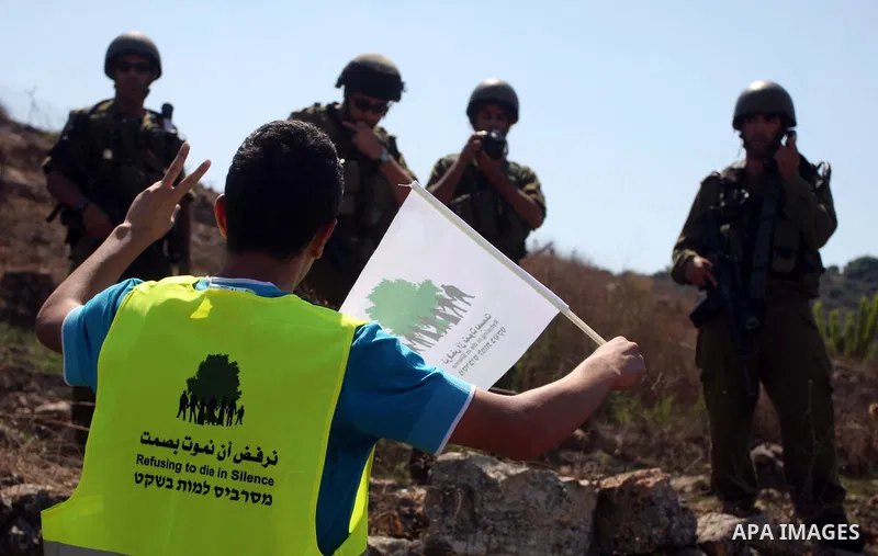 Israeli soldiers stand guard in front of members pro-Palestinian volunteer-based campaign which will intervene and respond to cases of violence towards Palestinians by Jewish settlers in the West Bank, in the West Bank v...