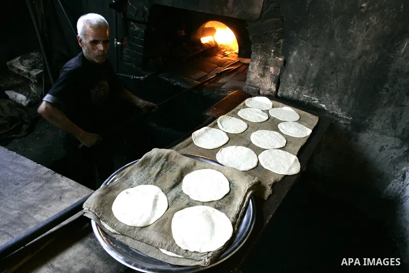 A Palestinian man bakes bread in a traditional mud oven in Rafah refugee camp, southern Gaza Strip on September 19, 2011. A diplomatic showdown looms at the United Nations this month when Palestinian President Mahmoud Ab...