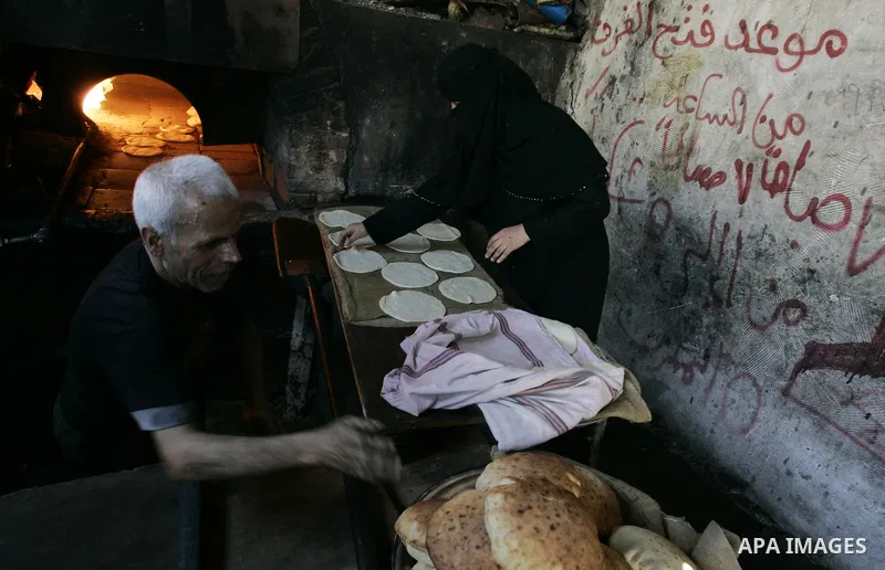 A Palestinian man bakes bread in a traditional mud oven in Rafah refugee camp, southern Gaza Strip on September 19, 2011. A diplomatic showdown looms at the United Nations this month when Palestinian President Mahmoud Ab...