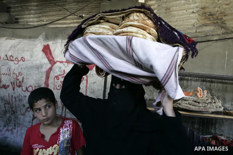 A Palestinian woman bakes bread in a traditional mud oven in Rafah refugee camp, southern Gaza Strip on September 19, 2011. A diplomatic showdown looms at the United Nations this month when Palestinian President Mahmoud...