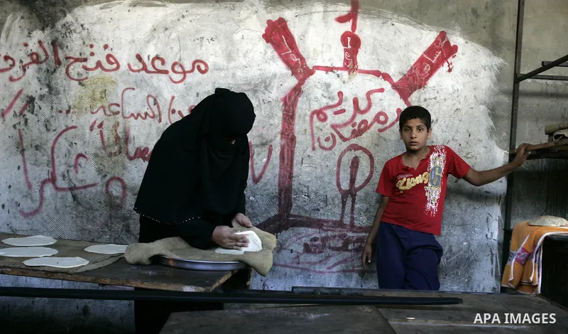 A Palestinian woman bakes bread in a traditional mud oven in Rafah refugee camp, southern Gaza Strip on September 19, 2011. A diplomatic showdown looms at the United Nations this month when Palestinian President Mahmoud...