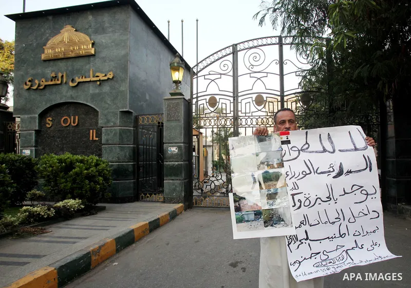 An Egyptian man holds slogan in a protest against the reassertion of the Emergency Law in the wake of the attack on the Israeli Embassy on 9 September. Egyptian activists marching through the street holding signs and cha...
